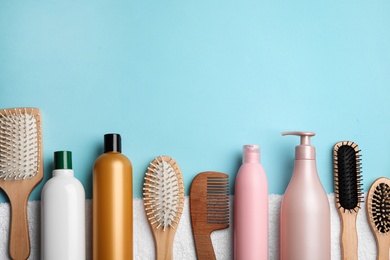 Flat lay composition with hair cosmetic products and tools on blue background. Space for text