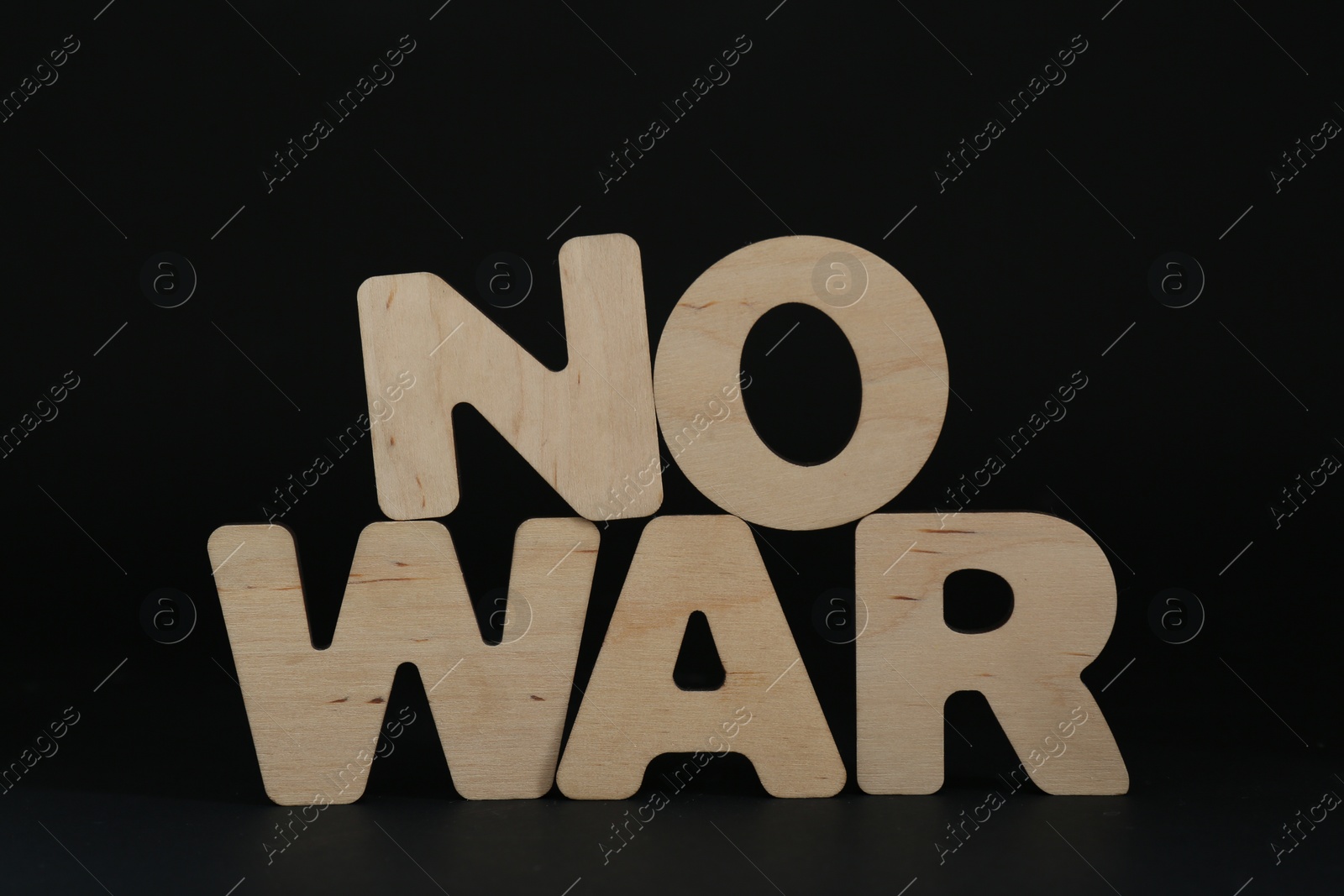 Photo of Words No War made of wooden letters on black background