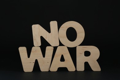 Photo of Words No War made of wooden letters on black background
