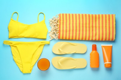 Flat lay composition with different beach objects on light blue background