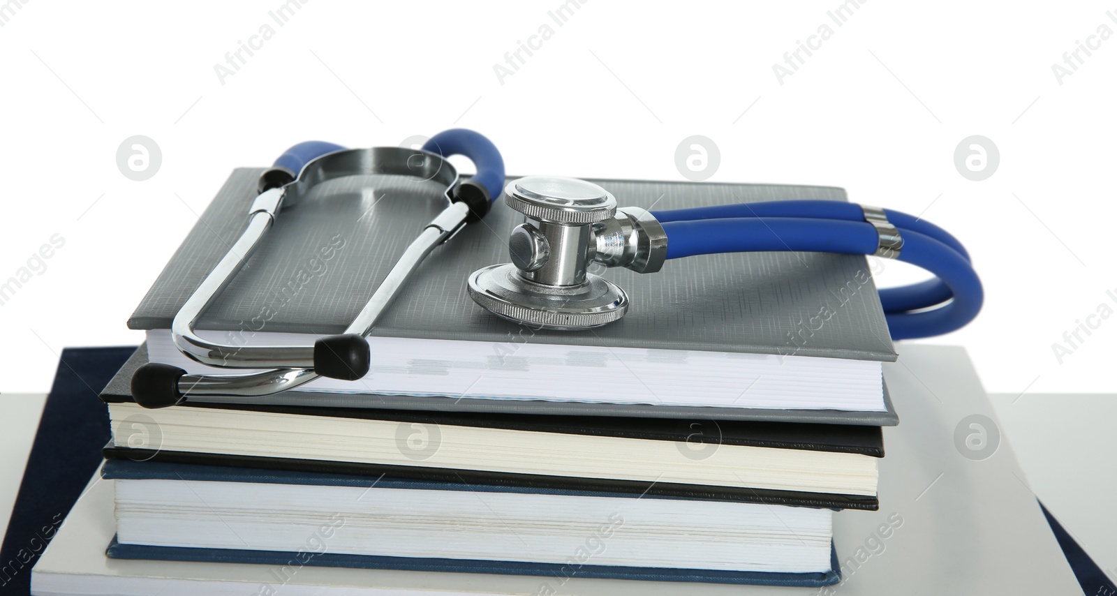 Photo of Stethoscope and stack of books isolated on white