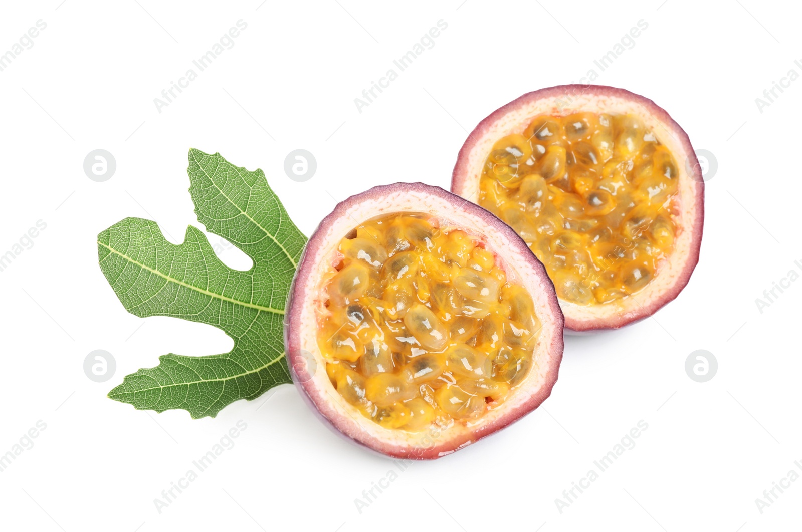 Photo of Halves of fresh ripe passion fruit (maracuya) with green leaf isolated on white