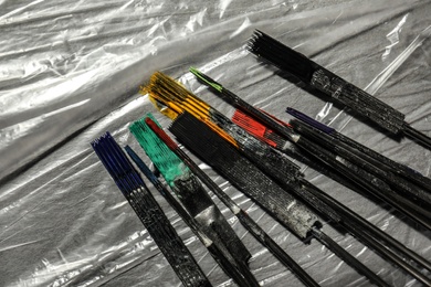 Photo of Tattoo needles covered with colorful inks on table, top view