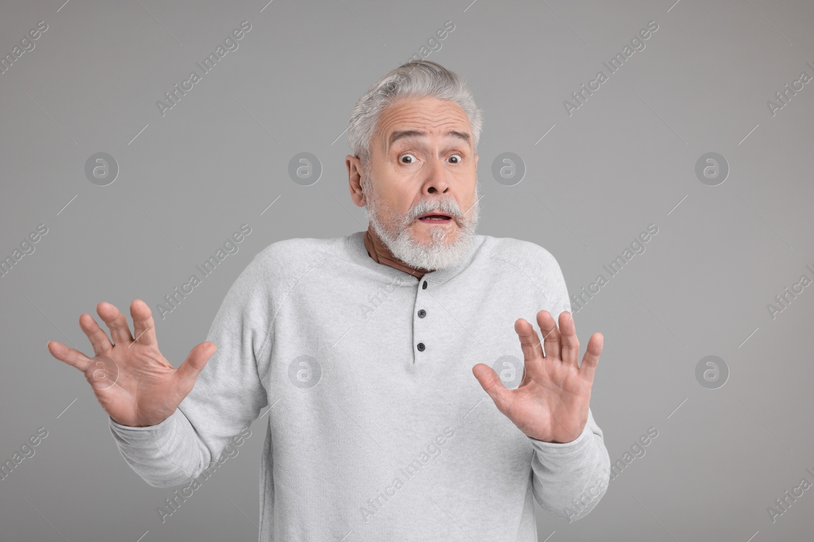 Photo of Portrait of surprised senior man on grey background