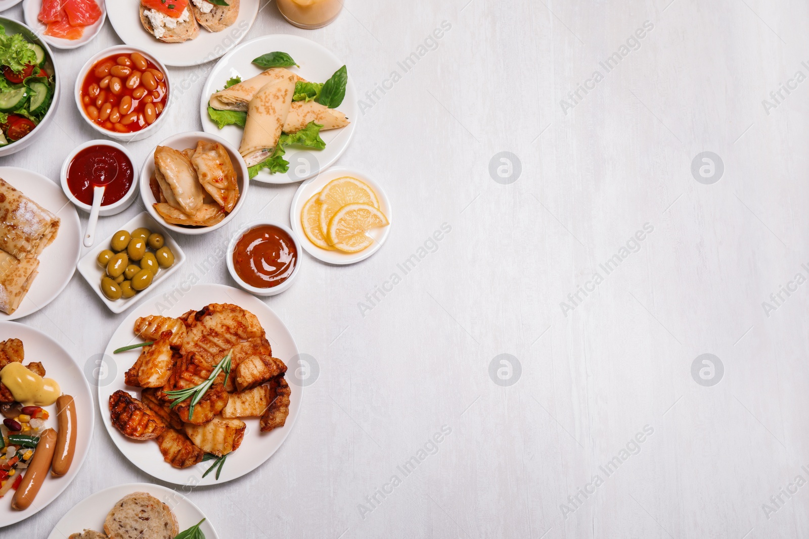 Photo of Buffet service. Flat lay composition with different dishes on white wooden table, space for text