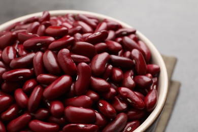 Raw red kidney beans in bowl on table, closeup