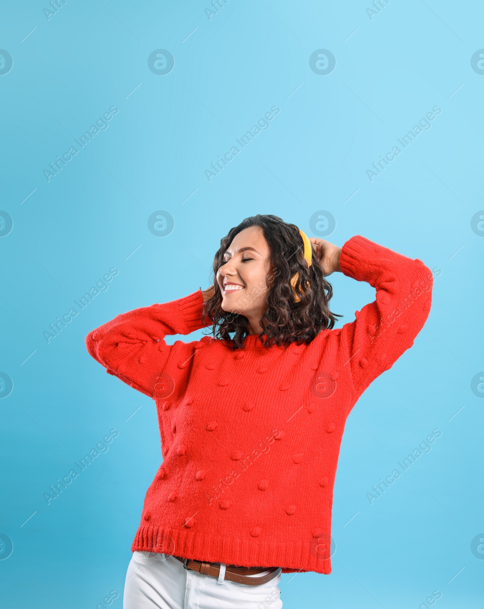 Photo of Happy young woman with headphones on blue background