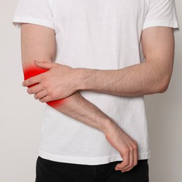 Man suffering from rheumatism on light background, closeup