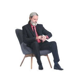 Photo of Handsome bearded mature man in suit sitting in armchair on white background