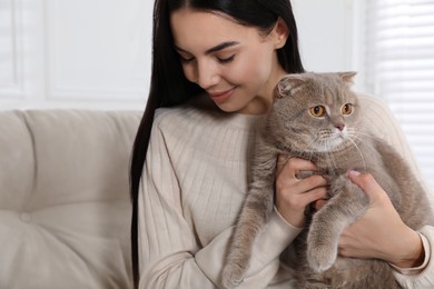Photo of Woman with her adorable cat on sofa at home