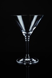Photo of New empty martini glass on black background