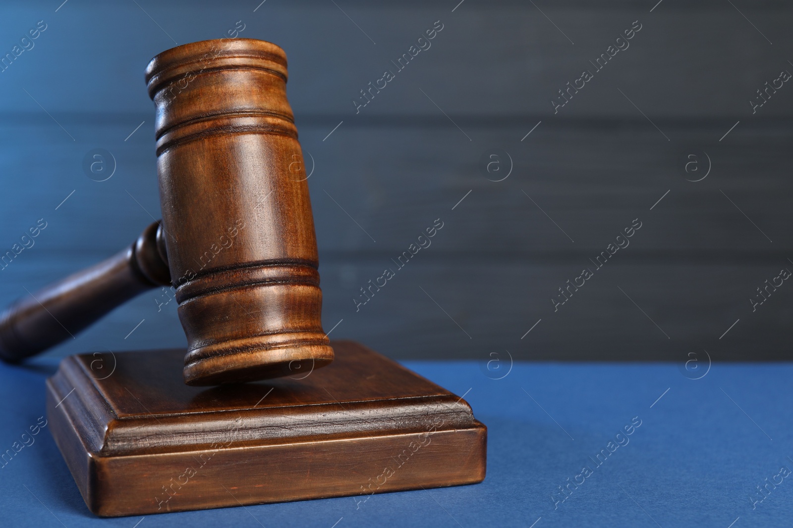 Photo of Wooden gavel on blue table, closeup. Space for text