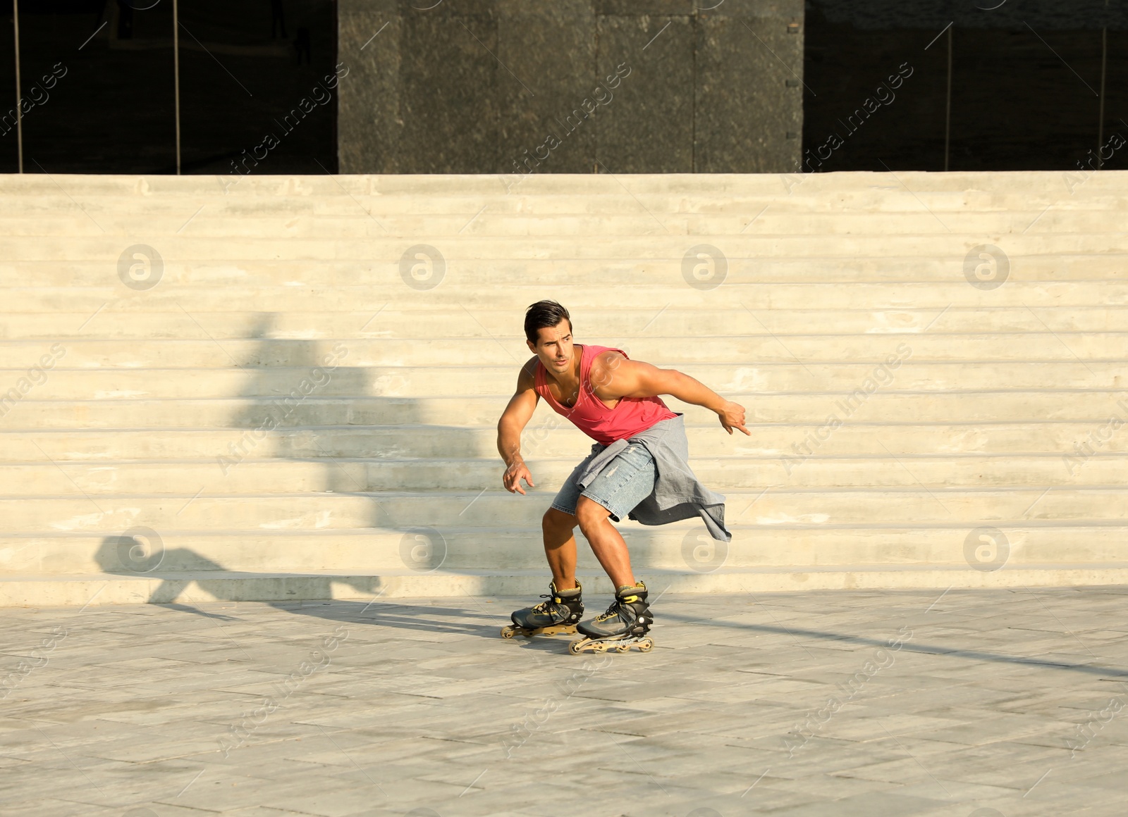 Photo of Handsome young man roller skating on city street, space for text