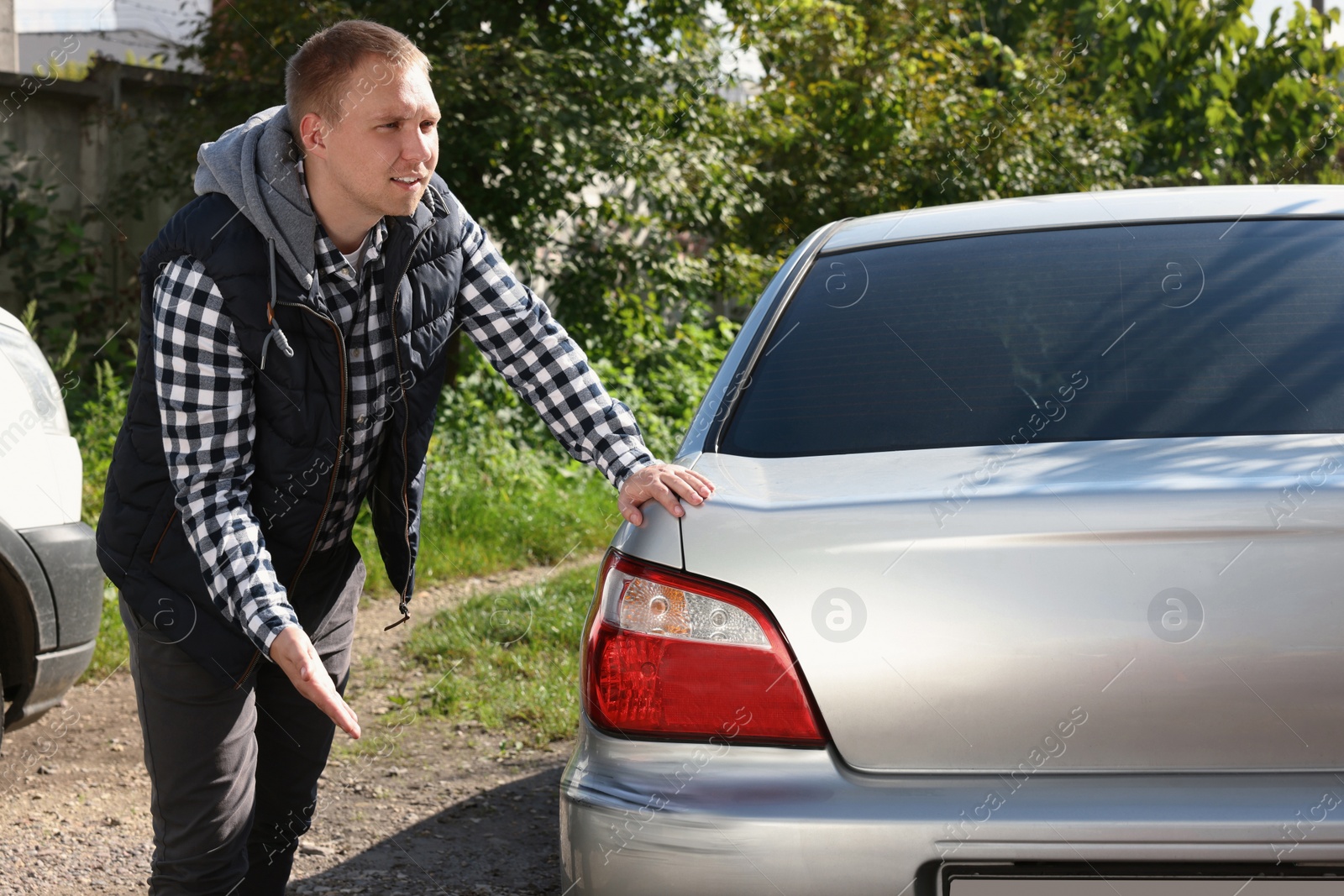 Photo of Stressed man near car with scratch outdoors