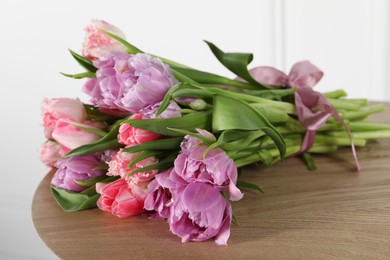 Photo of Beautiful bouquet of colorful tulip flowers on wooden table