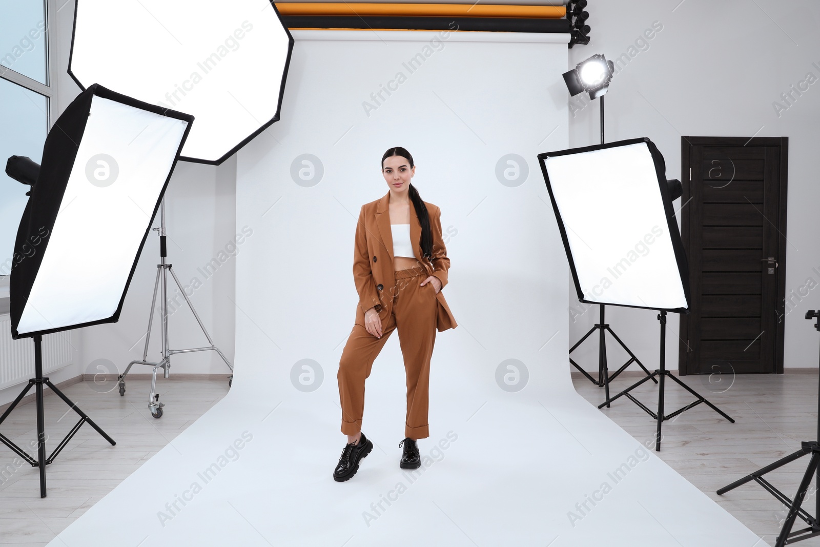 Photo of Beautiful young model posing in modern studio. Professional photo session