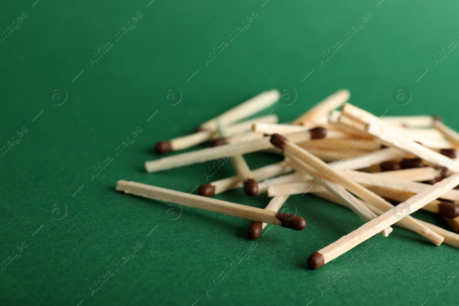 Photo of Heap of matches on color background, space for text