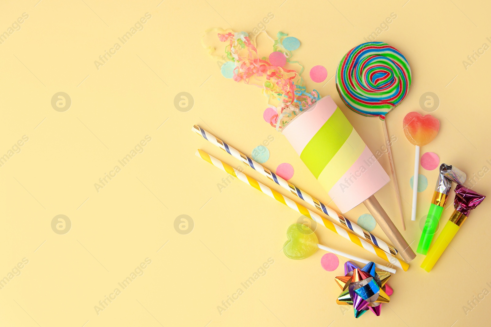 Photo of Party cracker and different festive items on beige background, flat lay. Space for text