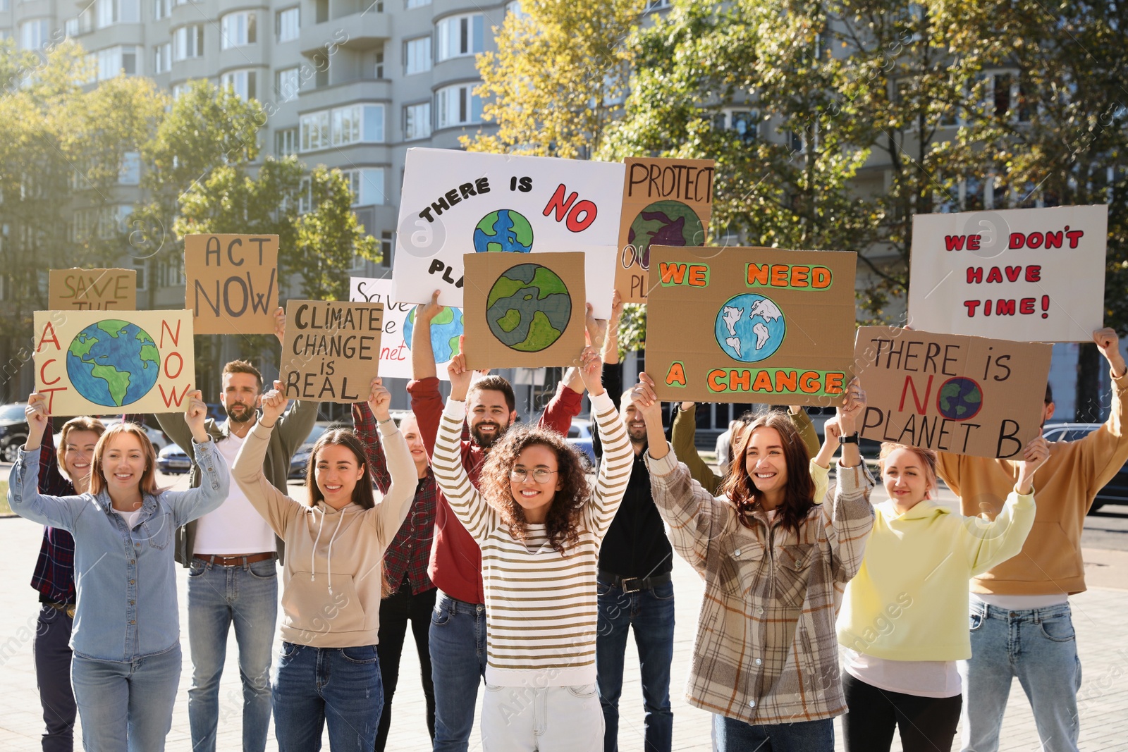 Photo of Group of people with posters protesting against climate change on city street