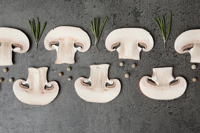 Photo of Flat lay composition of sliced fresh champignon mushrooms on gray background