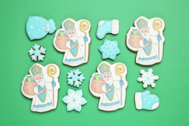Photo of Tasty cookies on green background, flat lay. St. Nicholas Day celebration