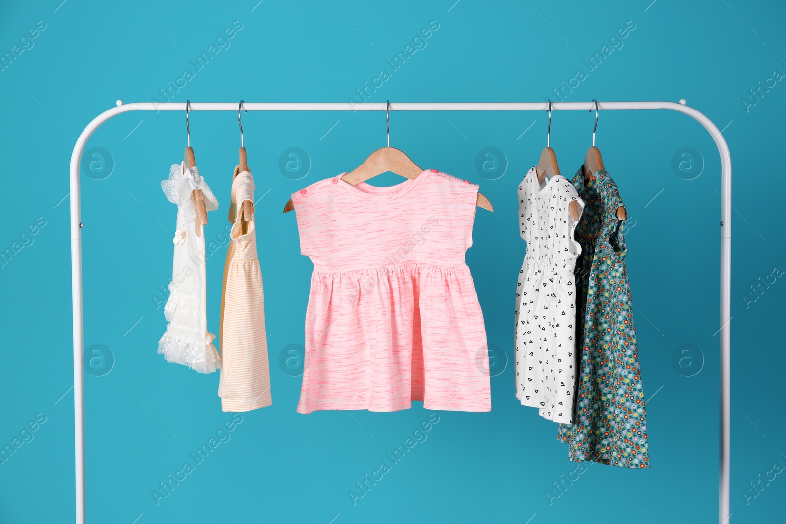 Photo of Rack with stylish child clothes on color background