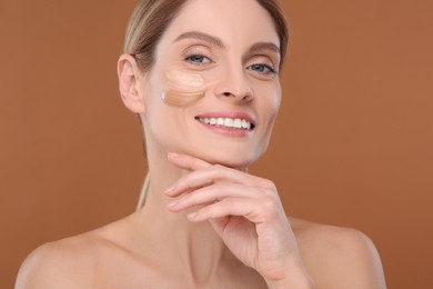 Photo of Woman with swatches of foundation on face against brown background