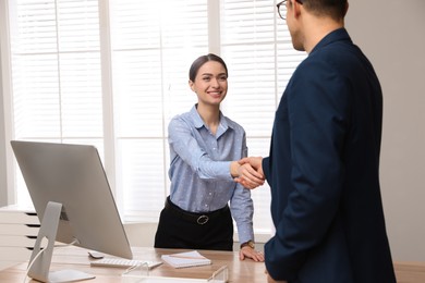 Man shaking hands with intern in office