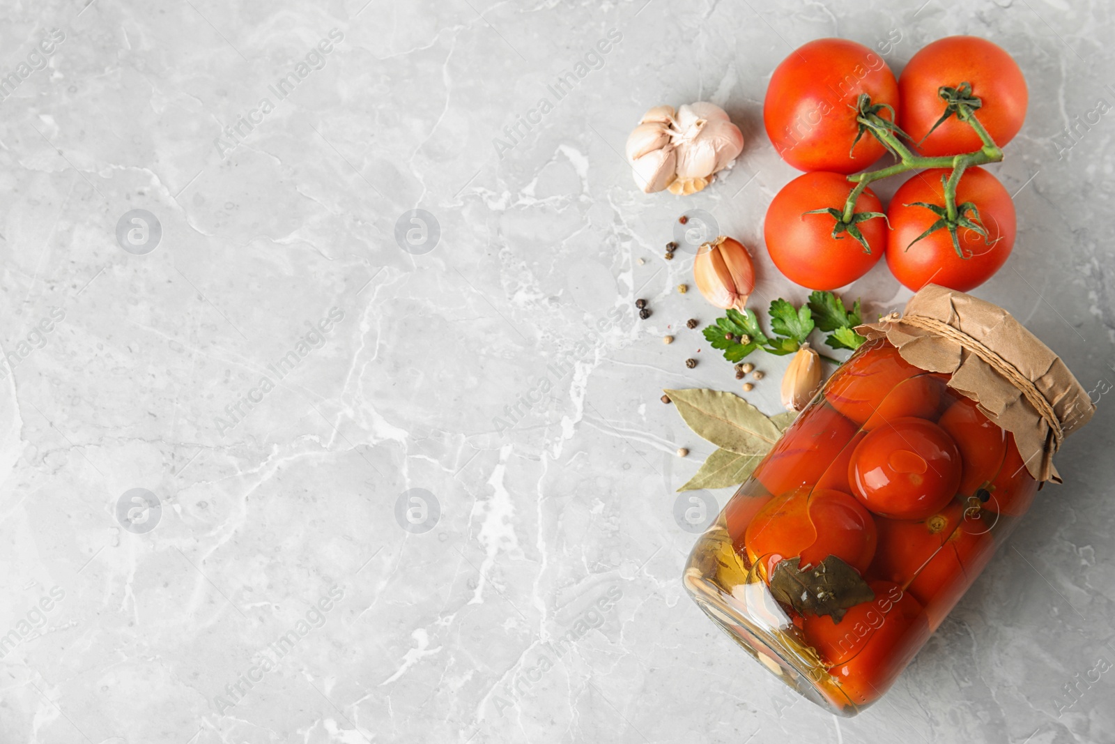 Photo of Flat lay composition with pickled tomatoes in glass jar on grey table, space for text