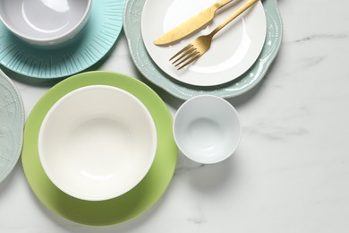 Photo of Beautiful ceramic dishware and cutlery on white marble table, flat lay. Space for text