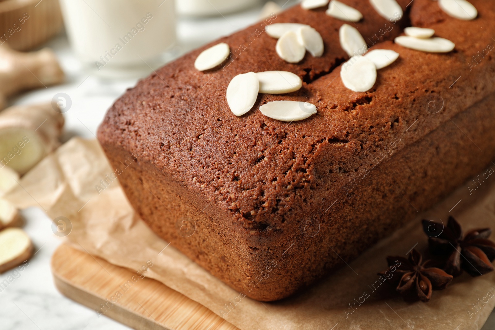 Photo of Delicious gingerbread cake with almond petals on table, closeup