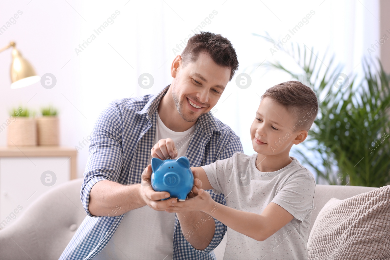 Photo of Family with piggy bank and money at home