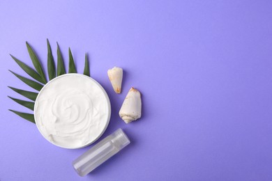 Photo of Jar of cream, green leaf, seashells and shampoo sample on violet background, flat lay. Space for text