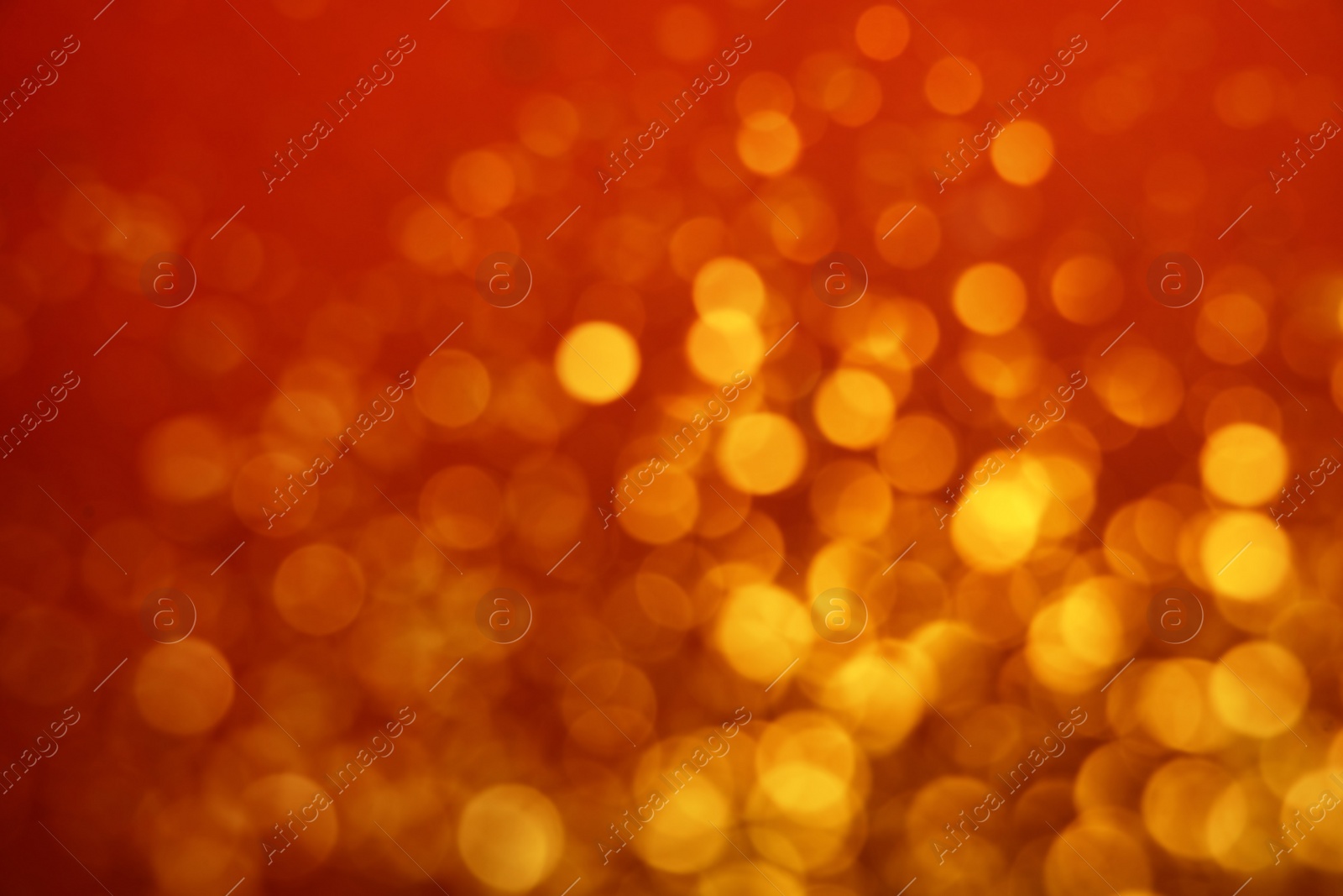 Photo of Blurred view of golden lights on red background. Bokeh effect