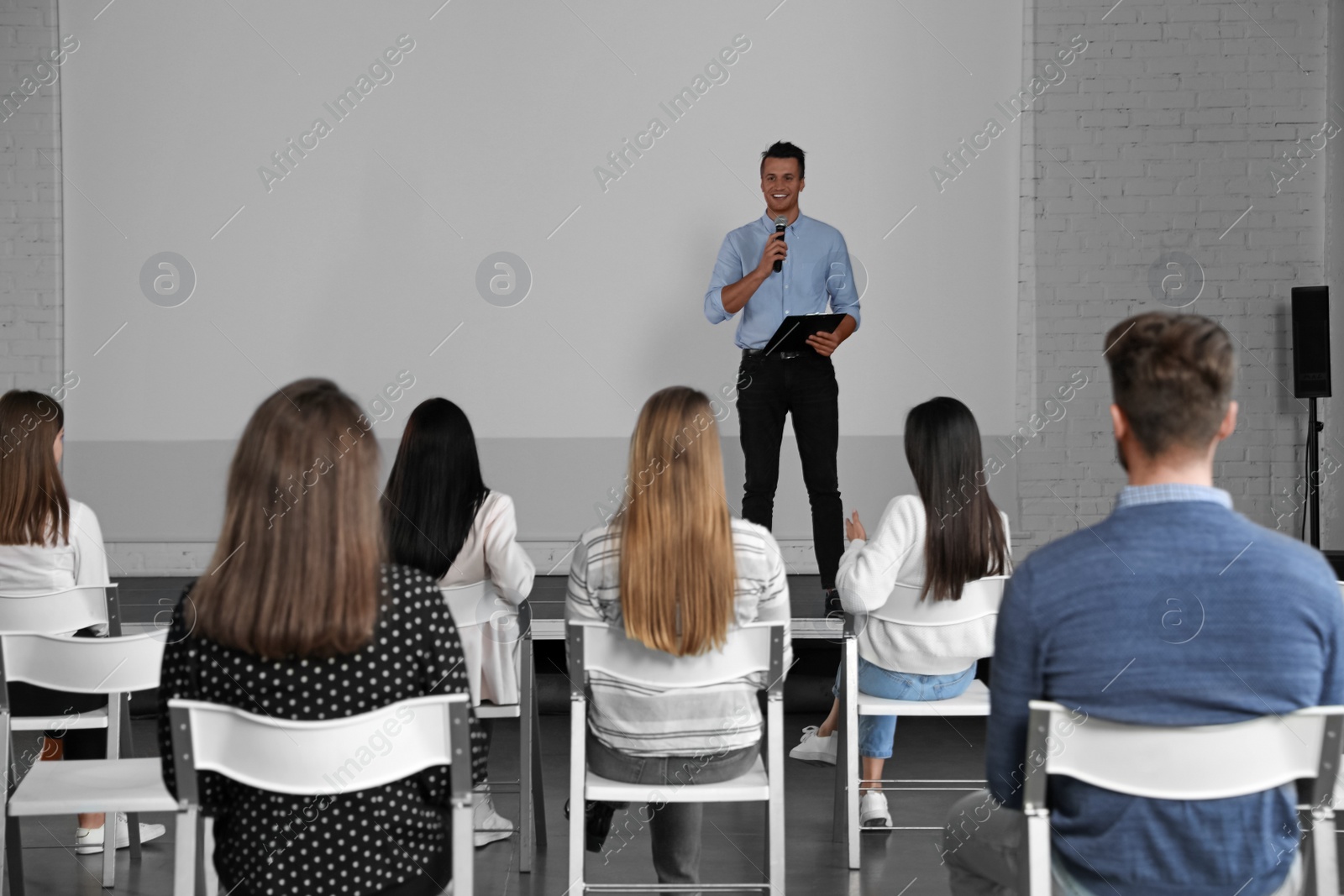 Photo of Male business trainer giving lecture in conference room with projection screen