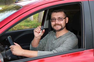 Photo of Man showing car key from new automobile