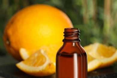 Photo of Bottle of citrus essential oil on blurred background, closeup. Space for text