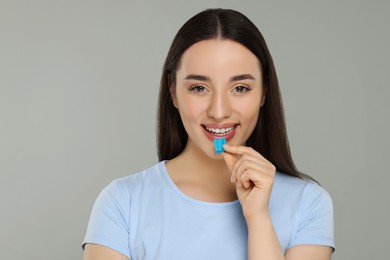 Photo of Happy young woman with bubble gum on color background
