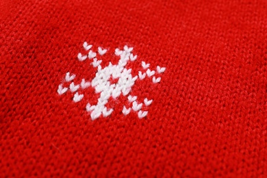 Warm red Christmas sweater with snowflake as background, closeup view