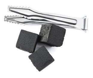 Photo of Charcoal cubes for hookah and tongs on white background, top view