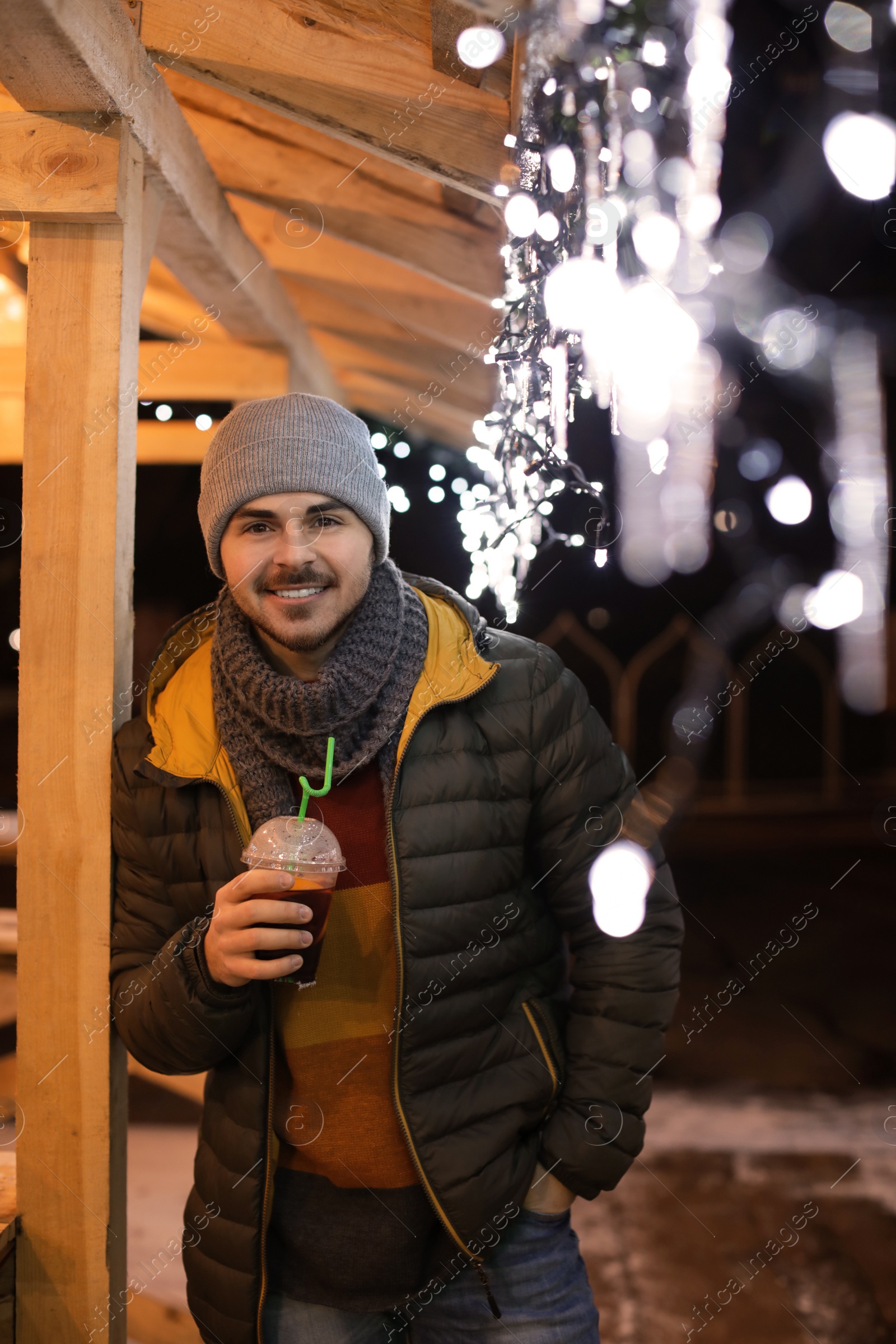 Photo of Man with cup of mulled wine at winter fair