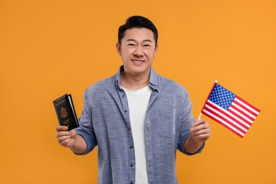Photo of Immigration. Happy man with passport and American flag on orange background