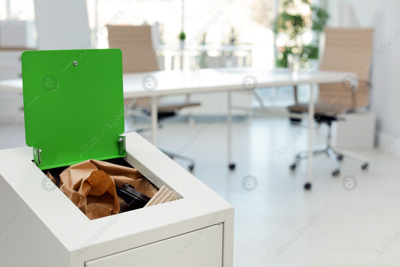 Photo of Open full trash bin in modern office, space for text. Waste recycling