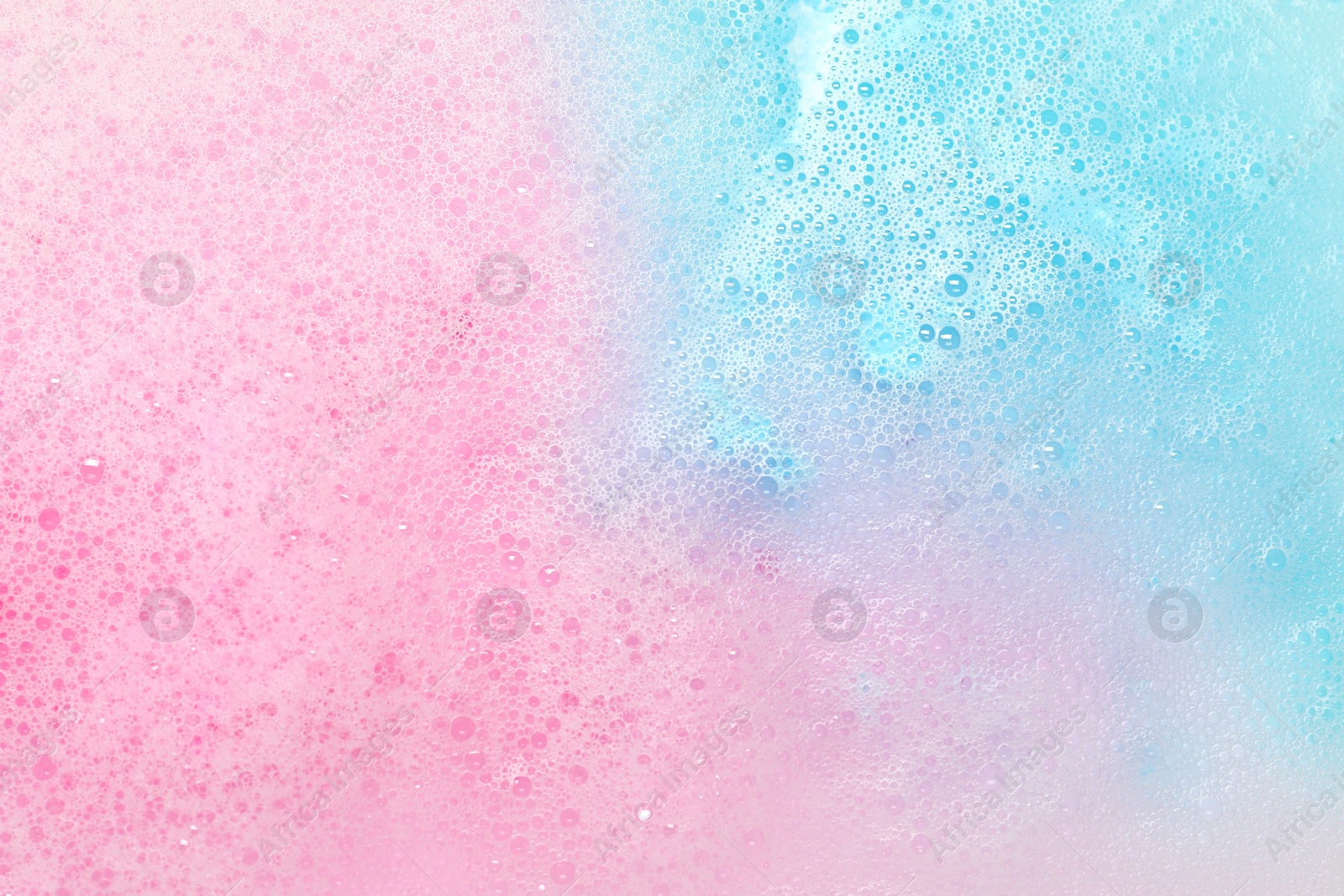 Photo of Colorful foam after dissolving bath bomb in water, closeup