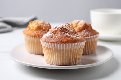 Photo of Delicious fresh sweet muffins on white table, closeup