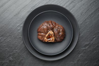 Photo of Piece of tasty grilled beef meat on black table, top view