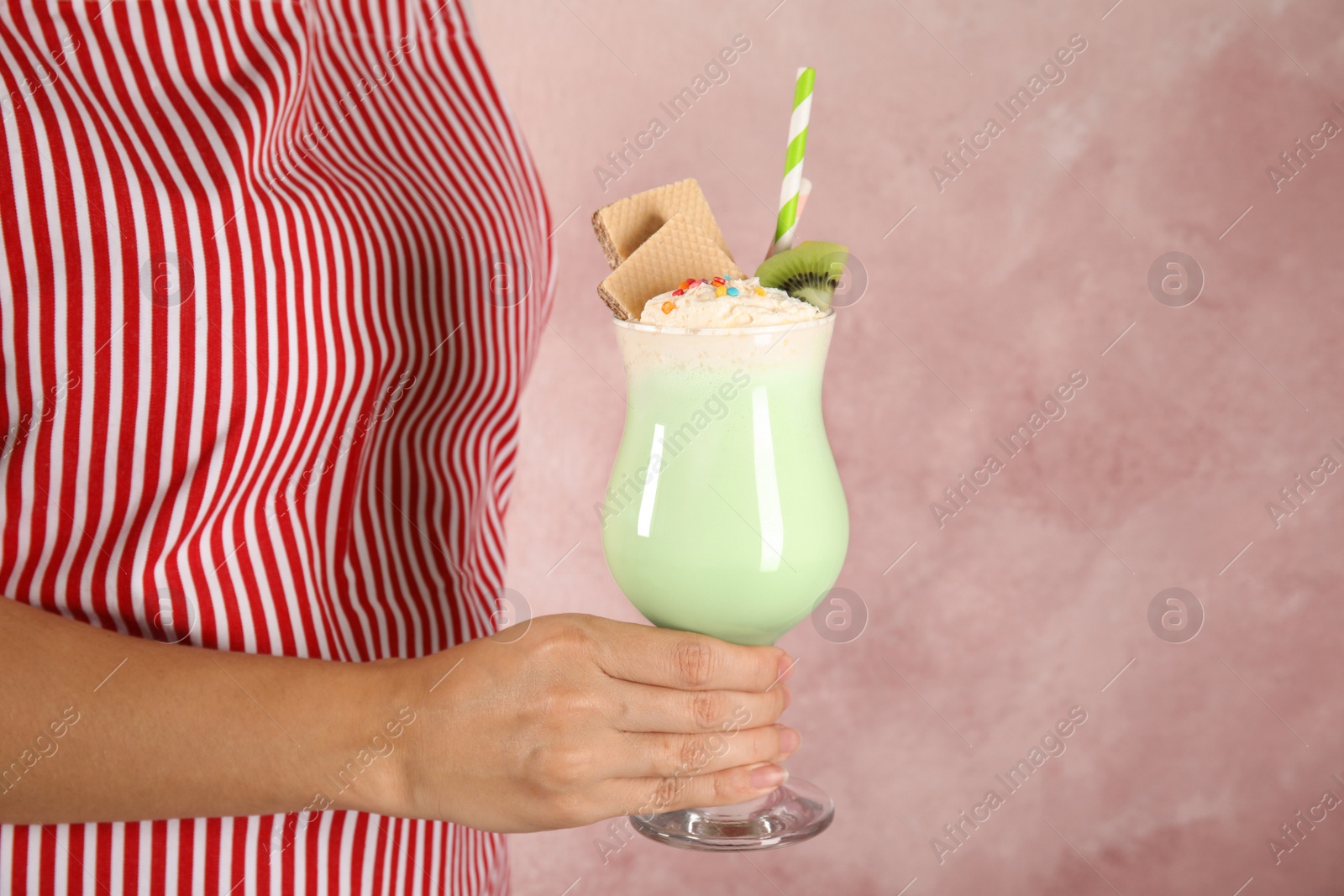 Photo of Woman with glass of delicious milk shake on color background, closeup. Space for text