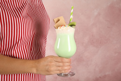 Photo of Woman with glass of delicious milk shake on color background, closeup. Space for text