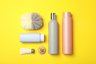 Photo of Flat lay composition with baby cosmetic products on yellow background