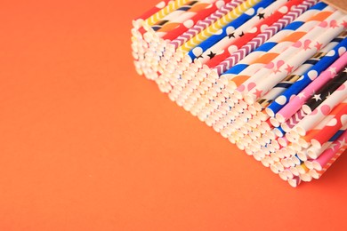 Photo of Many paper drinking straws on orange background. Space for text